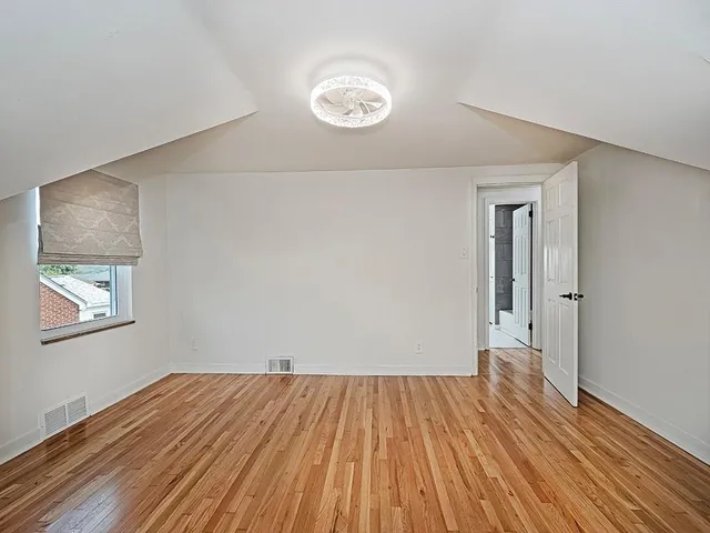 a view of a room with wooden floor and window