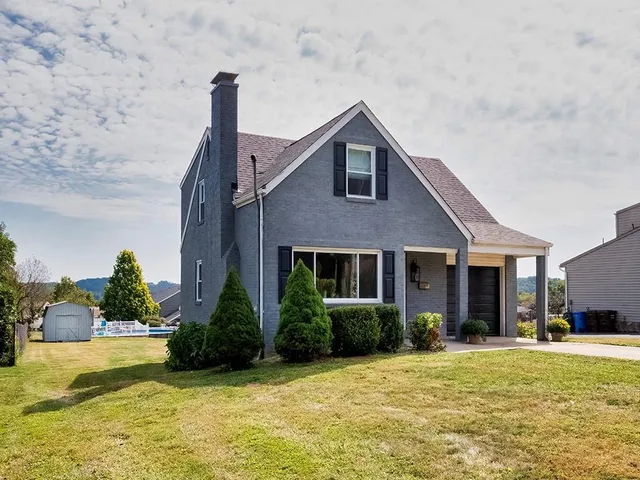 a front view of a house with a yard and palm trees