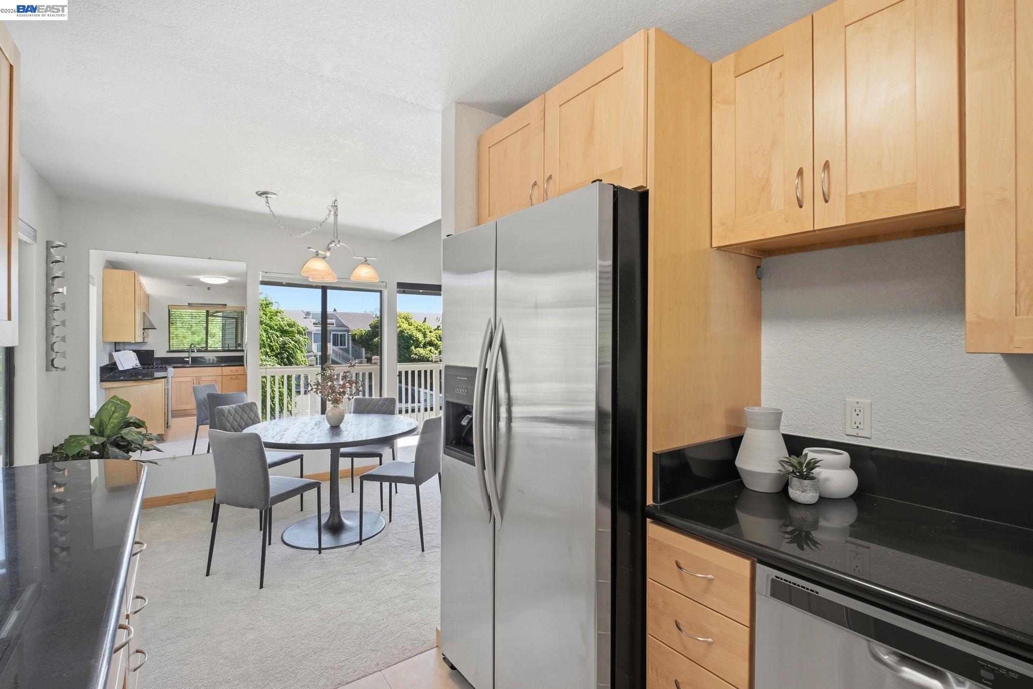 3395 Pinewood Terrace, Unit 304 Fremont, CA 94536 - Photo 12 of 33 a kitchen with stainless steel appliances granite countertop a refrigerator a sink dishwasher and white cabinets with wooden floor