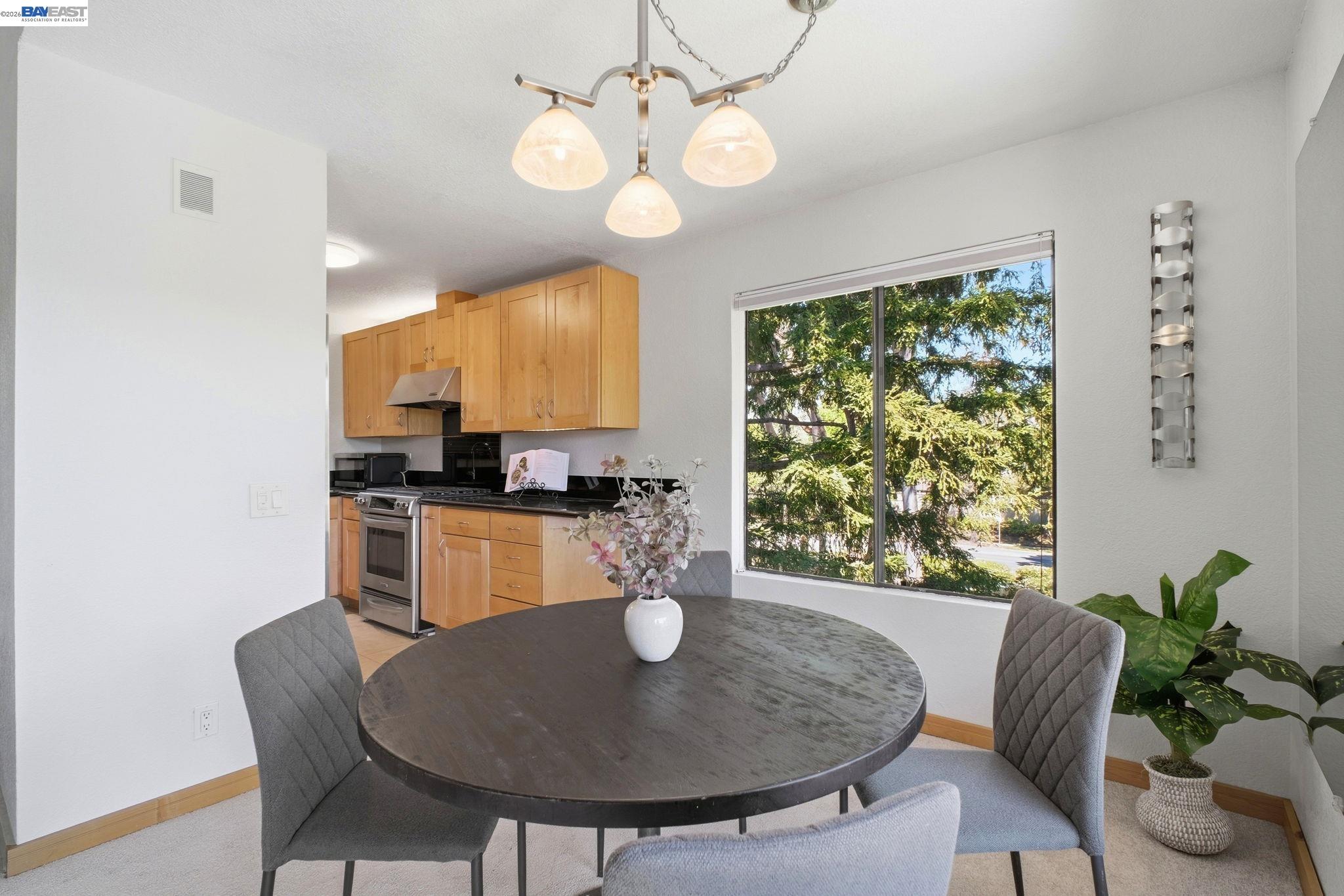 3395 Pinewood Terrace, Unit 304 Fremont, CA 94536 - Photo 14 of 33 a view of a dining room with furniture a chandelier and wooden floor