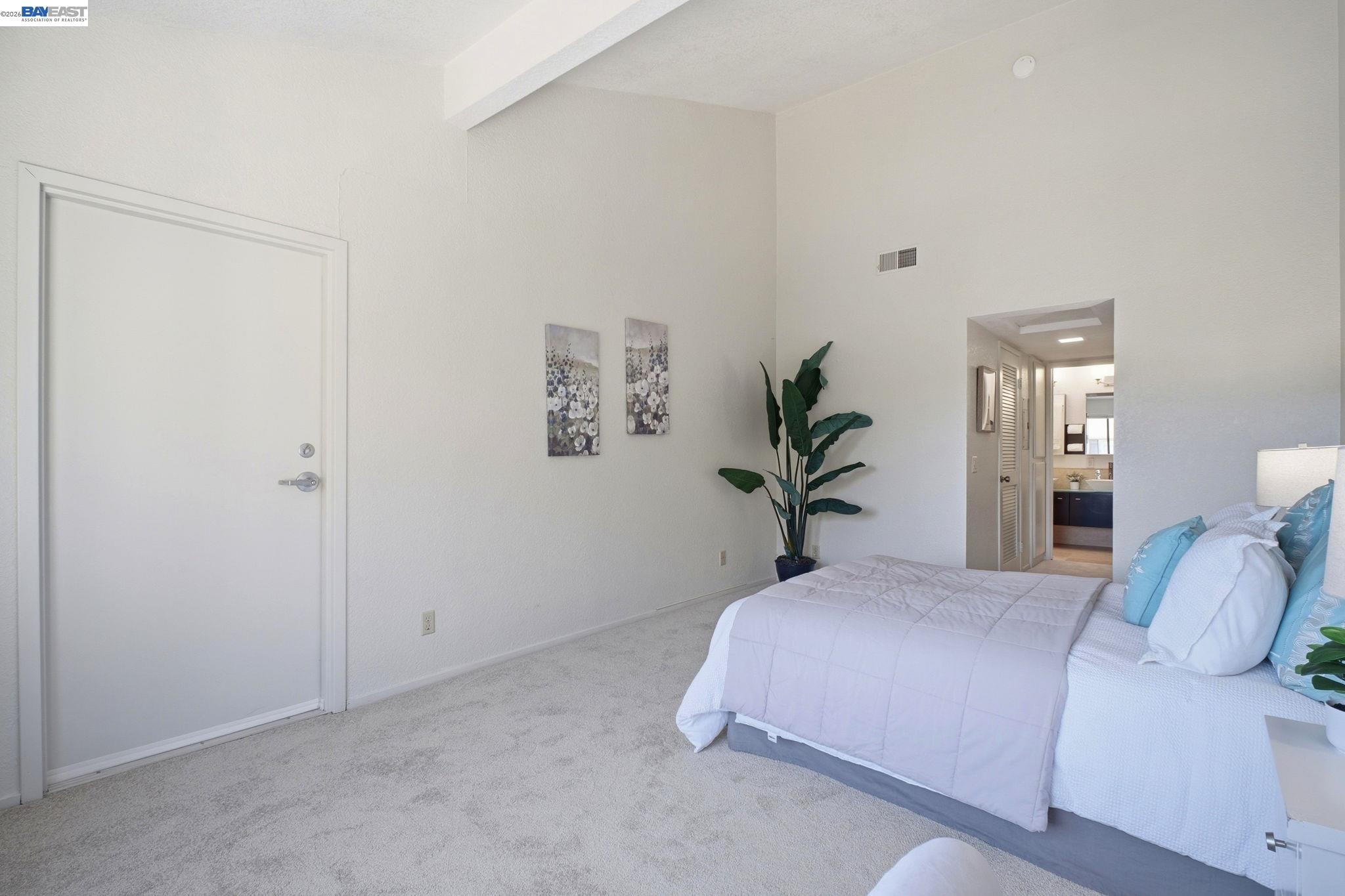 3395 Pinewood Terrace, Unit 304 Fremont, CA 94536 - Photo 21 of 33 a bedroom with a large bed and a potted plant