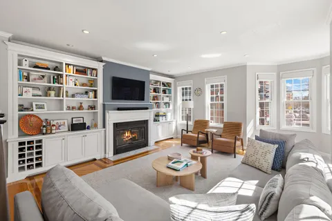 a living room with furniture a fireplace and a flat screen tv