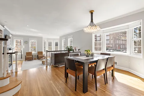 a view of a a dining room with furniture window and wooden floor