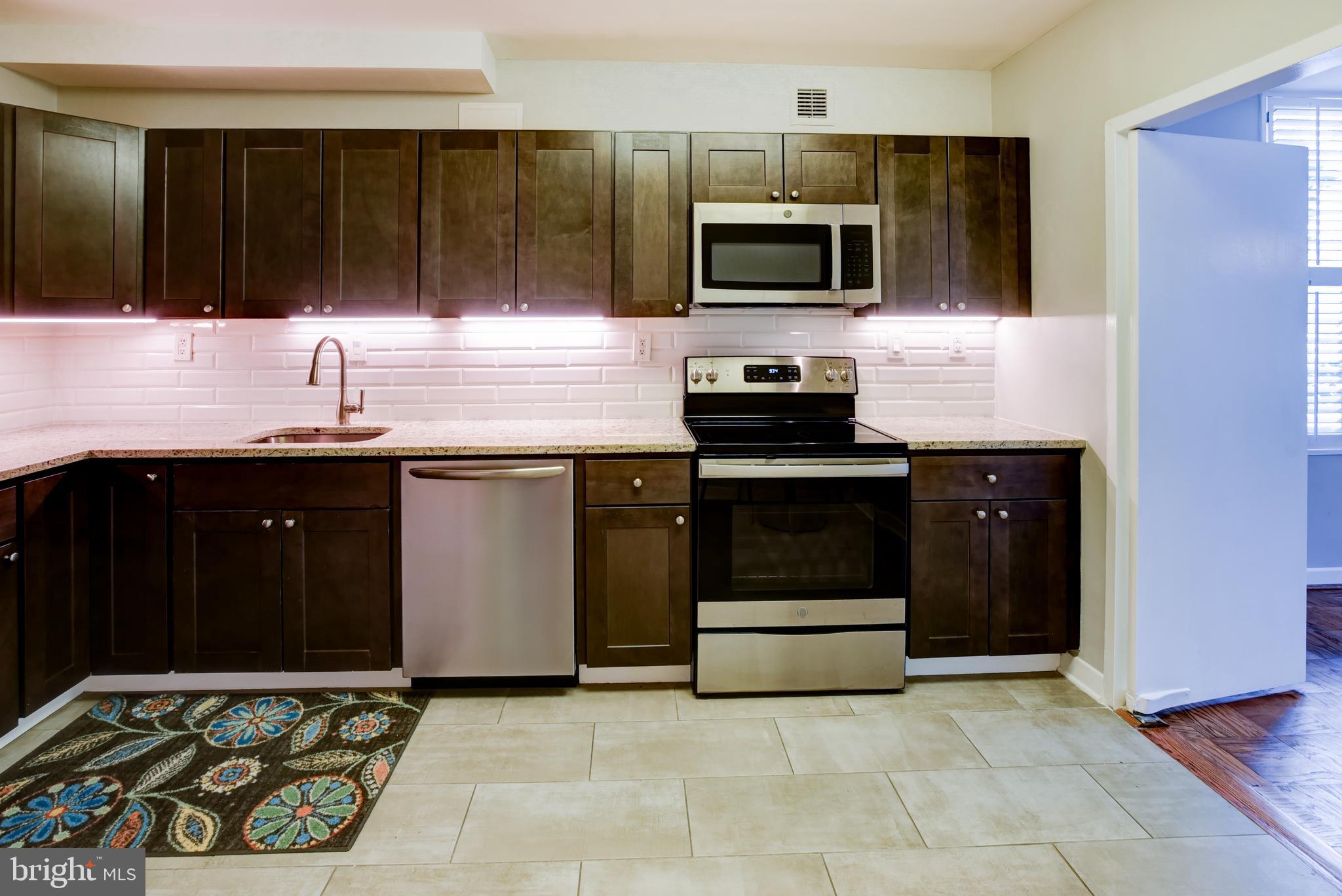 4100 Cathedral Avenue Northwest, Unit 512 Washington, DC 20016 - Photo 16 of 71 a kitchen with a sink and a stove top oven