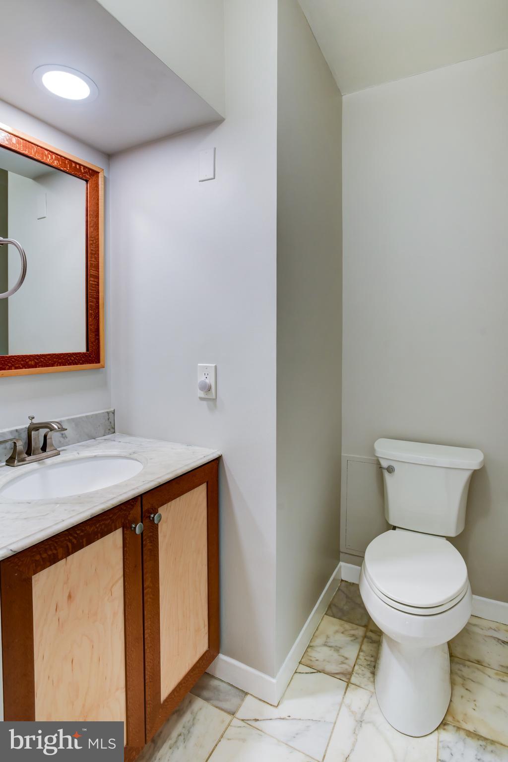 4100 Cathedral Avenue Northwest, Unit 512 Washington, DC 20016 - Photo 31 of 71 a bathroom with a toilet a sink and mirror
