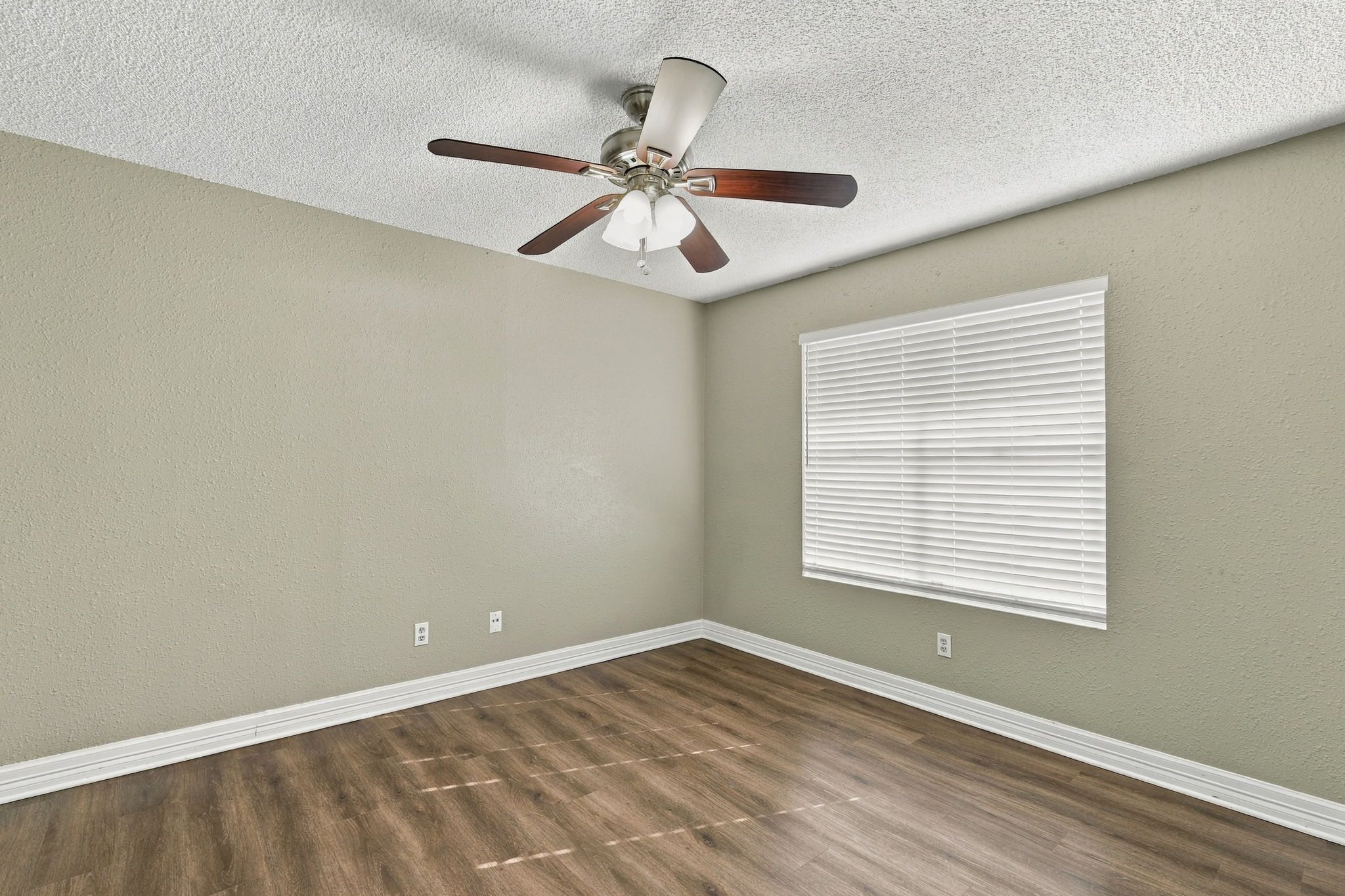 8804 Schick Road, Unit C Austin, TX 78729 - Photo 9 of 17 Rich wood-look flooring and crisp white trim enhance this versatile bedroom space.