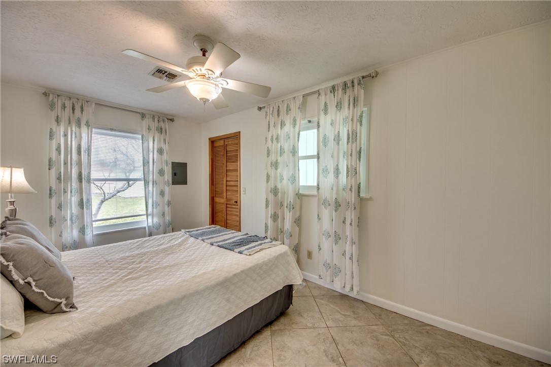 5892 Sailfish Road Bokeelia, FL 33922 - Photo 20 of 32 a spacious bedroom with a large bed and a chandelier