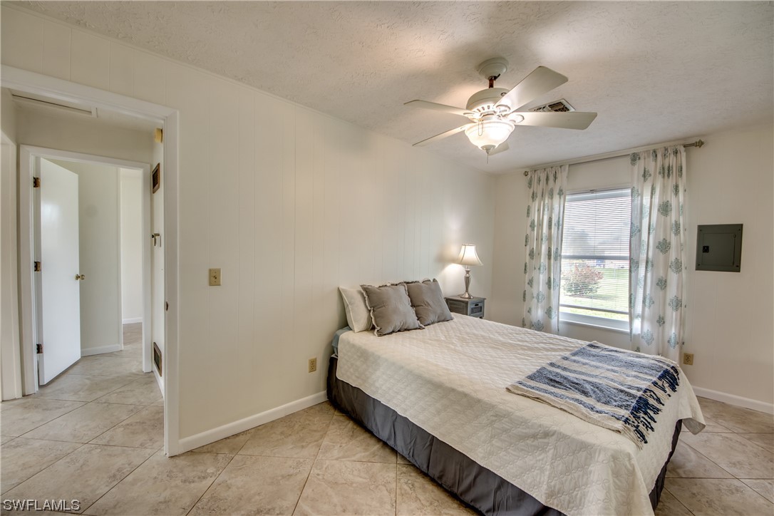 5892 Sailfish Road Bokeelia, FL 33922 - Photo 21 of 32 a bedroom with a bed and a chandelier