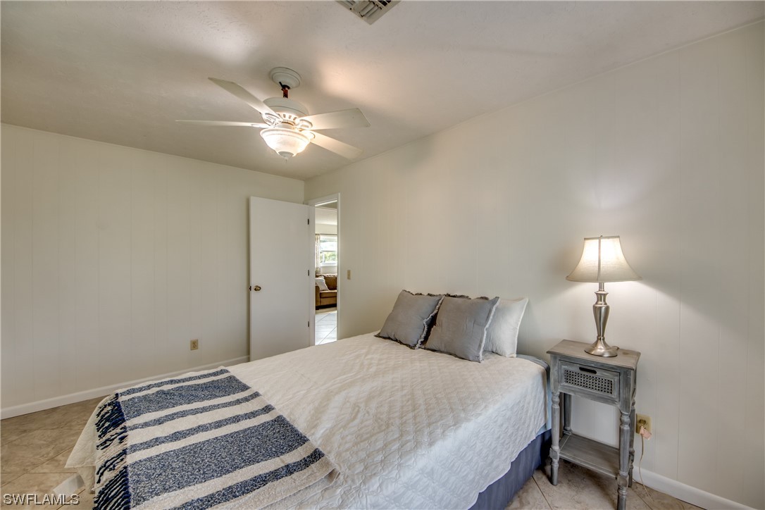 5892 Sailfish Road Bokeelia, FL 33922 - Photo 22 of 32 a bedroom with a bed and a lamp