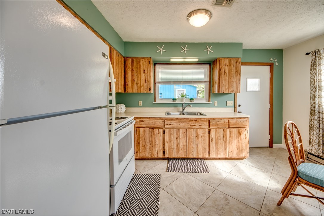 5892 Sailfish Road Bokeelia, FL 33922 - Photo 8 of 32 a kitchen with a sink appliances and a window