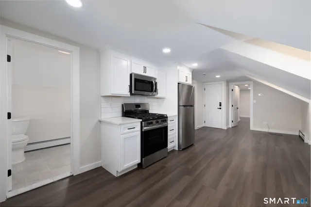 a kitchen with a refrigerator and a stove top oven