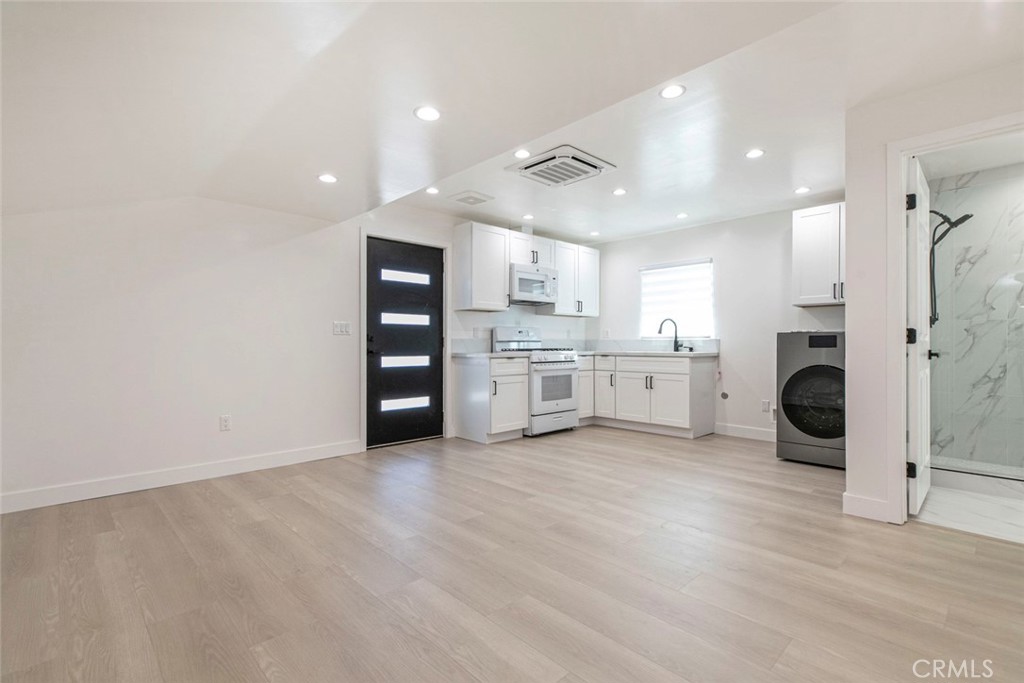 11321 Collett Avenue Granada Hills, CA 91344 - Photo 5 of 11 a view of a kitchen with a sink and dishwasher a refrigerator with wooden floor