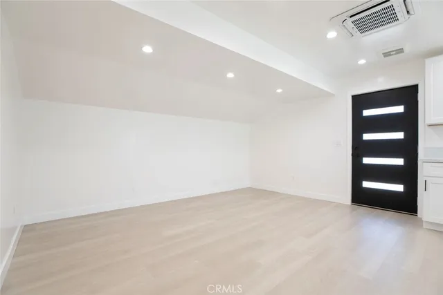 an empty room with closet and wooden floor