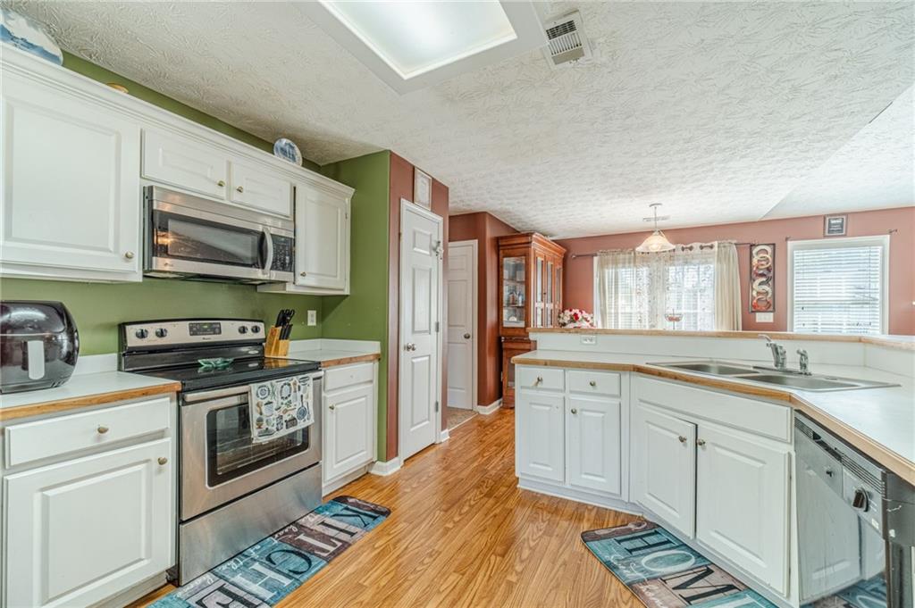 1185 Wendy Way Winder, GA 30680 - Photo 11 of 46 a kitchen with stainless steel appliances granite countertop a stove sink and cabinets