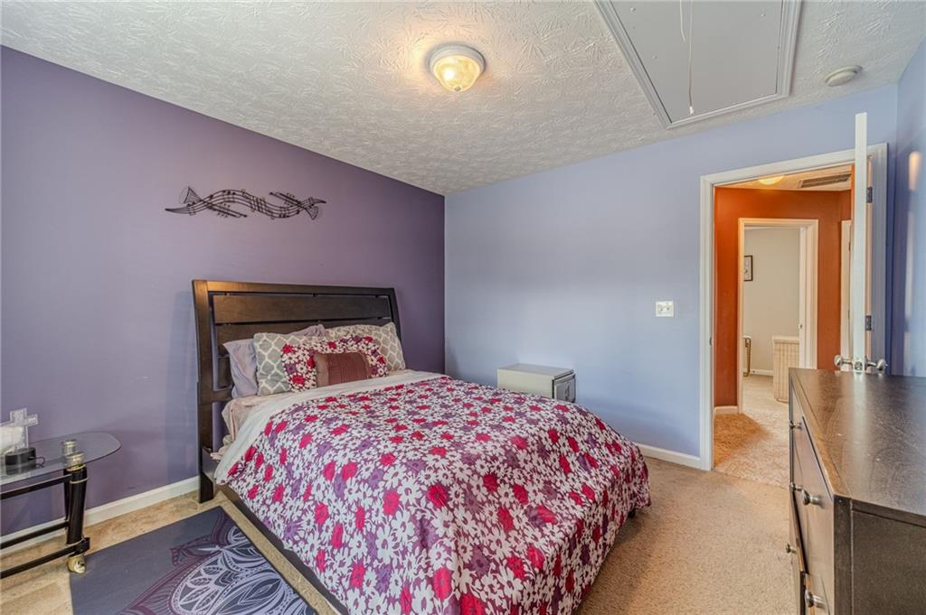 1185 Wendy Way Winder, GA 30680 - Photo 23 of 46 a bedroom with a bed and a lamp on dresser with wooden floor