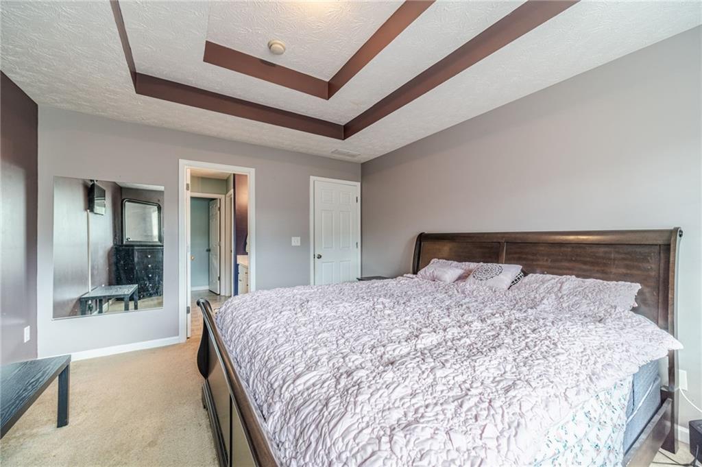 1185 Wendy Way Winder, GA 30680 - Photo 26 of 46 a bedroom with a large bed and a flat tv screen