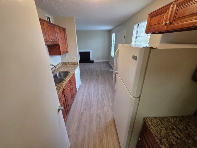 a view of a kitchen with wooden floor and a sink