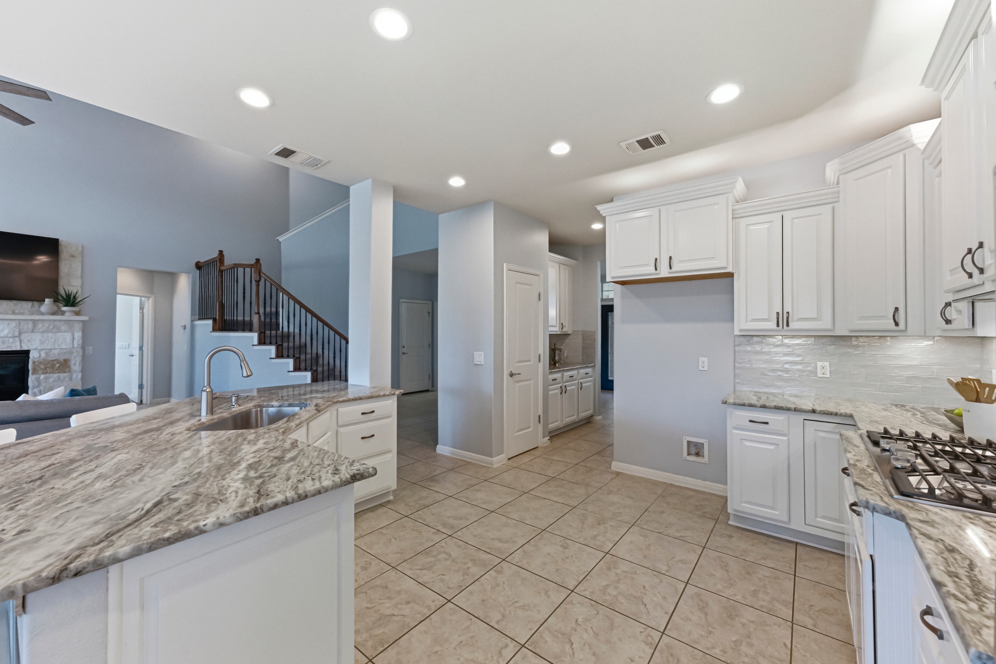1023 Grassy Field Road Austin, TX 78737 - Photo 12 of 39 a kitchen with granite countertop a refrigerator and a sink