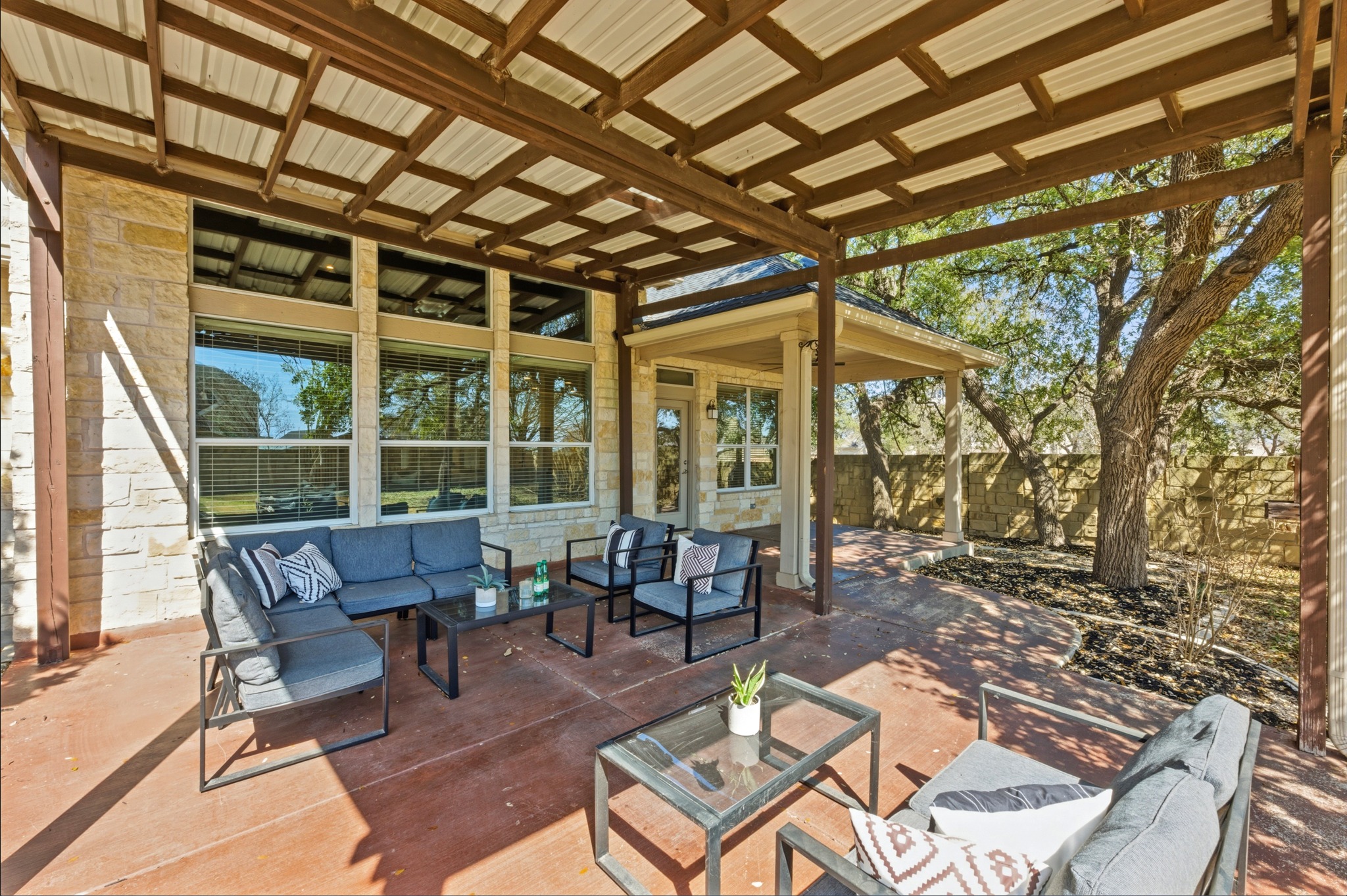 1023 Grassy Field Road Austin, TX 78737 - Photo 34 of 39 a view of a patio with table and chairs and floor to ceiling window