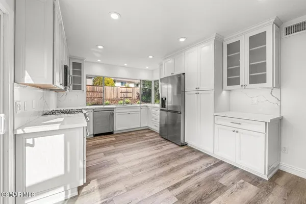 a kitchen with white cabinets and white appliances