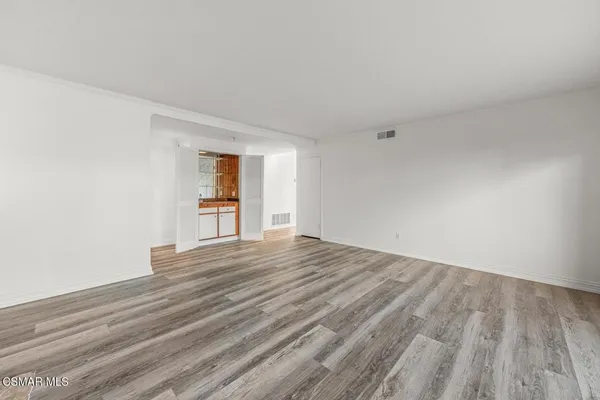 a view of a room with wooden floor and a window