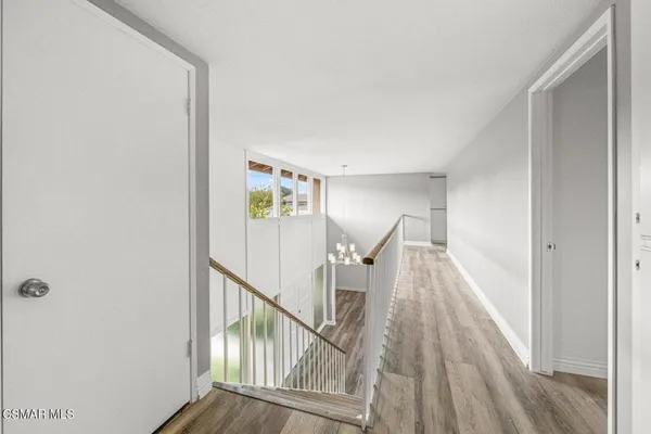 a view of a hallway with wooden floor and staircase