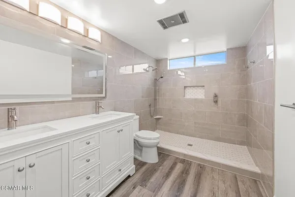 a bathroom with a double vanity sink toilet and shower