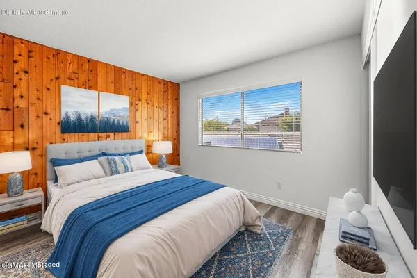 a bedroom with a bed and a flat screen tv