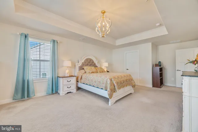 a bedroom with a large bed and a chandelier