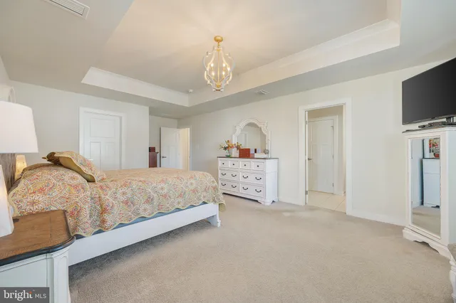 a spacious bedroom with a bed and a flat screen tv