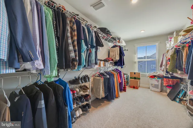 a view of walk in closet with clothes