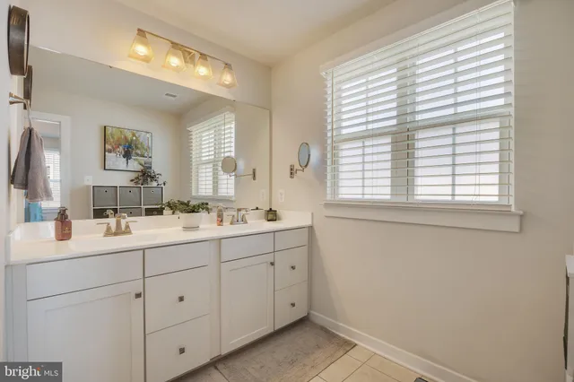 a bathroom with a double vanity sink and mirror with window