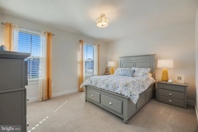 a spacious bedroom with a bed and a lamp