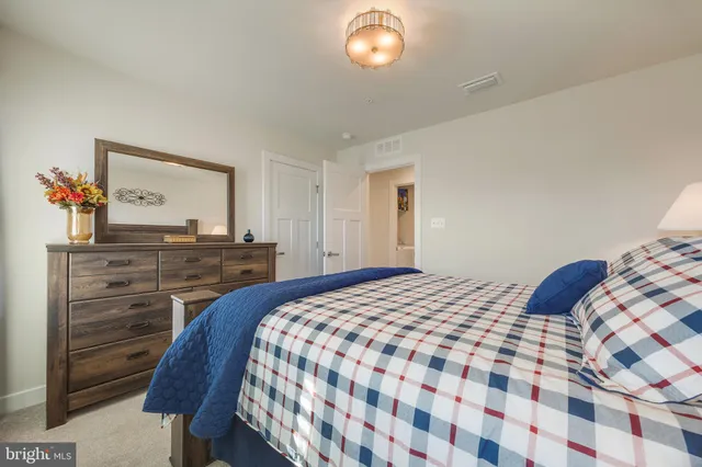 a bedroom with a bed and a lamp on dresser