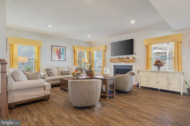 a living room with furniture a large window and a fireplace
