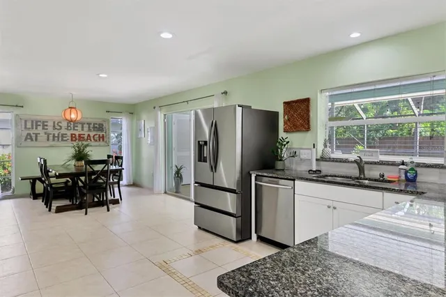 a kitchen with stainless steel appliances granite countertop a sink and a refrigerator