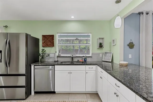 a kitchen with stainless steel appliances a sink and a refrigerator