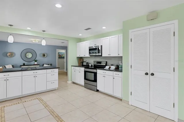 a kitchen with white cabinets and appliances