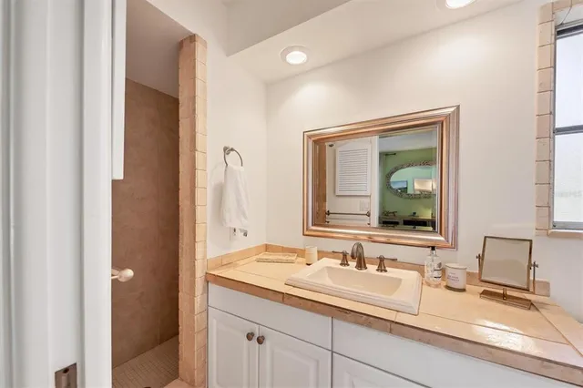a bathroom with a granite countertop sink and a mirror