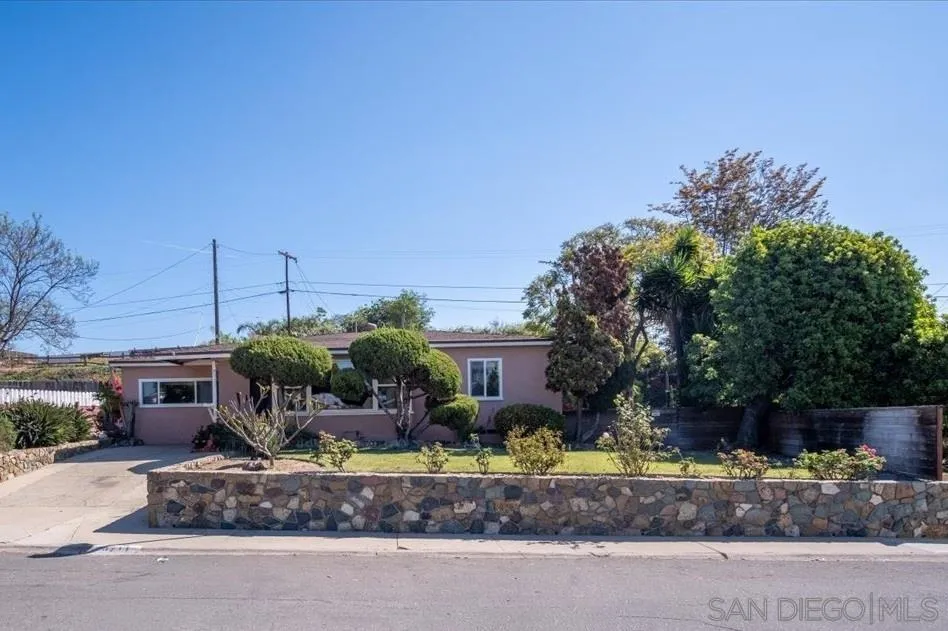 a front view of a house with a yard and potted plants