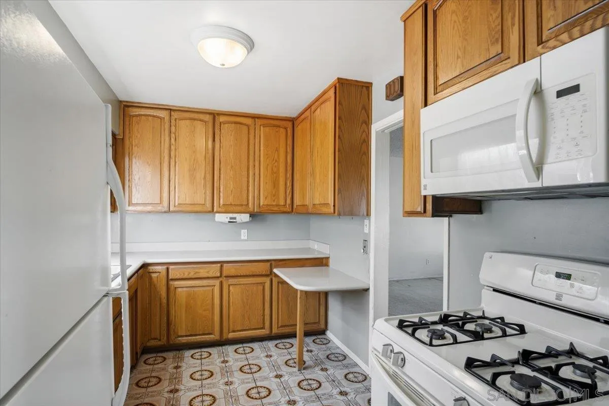 3711 Racine Road San Diego, CA 92115 - Photo 13 of 44 a kitchen with a sink stove and cabinets