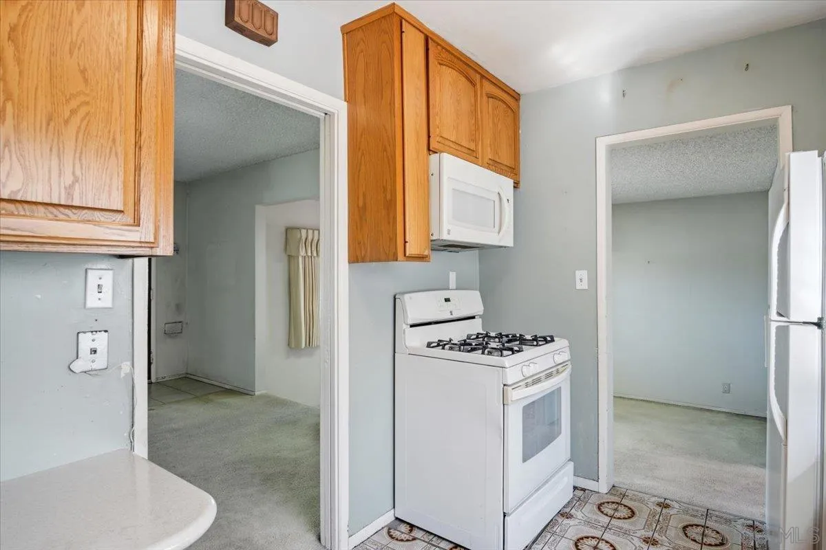 3711 Racine Road San Diego, CA 92115 - Photo 14 of 44 a kitchen with stainless steel appliances a stove a sink and a refrigerator