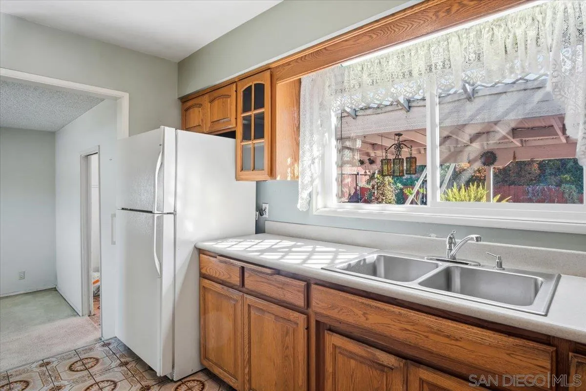 3711 Racine Road San Diego, CA 92115 - Photo 15 of 44 a kitchen with stainless steel appliances granite countertop a refrigerator and a sink