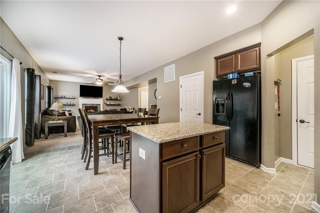 7678 West Berkeley Road Denver, NC 28037 - Photo 12 of 29 a kitchen with a kitchen island a stove a refrigerator and a dining table