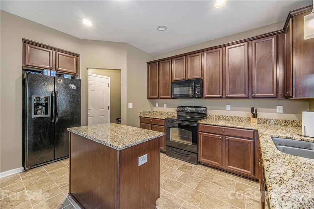 7678 West Berkeley Road Denver, NC 28037 - Photo 14 of 29 a kitchen with stainless steel appliances granite countertop a stove top oven a refrigerator and a sink