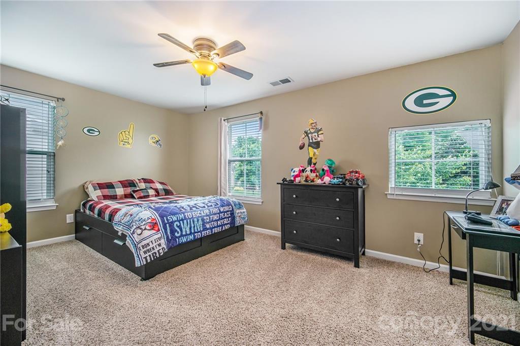 7678 West Berkeley Road Denver, NC 28037 - Photo 15 of 29 a bedroom with a bed and a chandelier