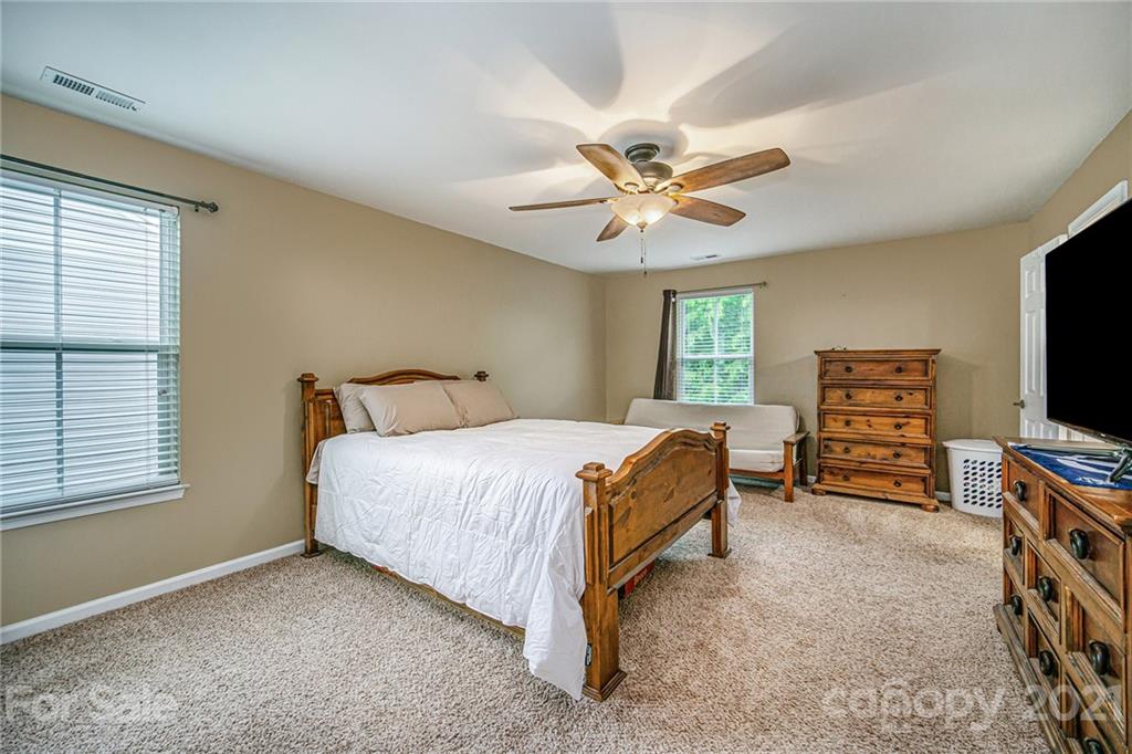 7678 West Berkeley Road Denver, NC 28037 - Photo 19 of 29 a bedroom with a bed and a flat screen tv