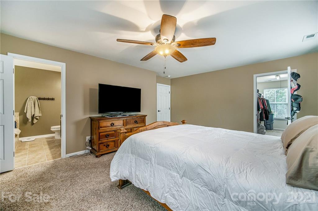 7678 West Berkeley Road Denver, NC 28037 - Photo 21 of 29 a bedroom with a bed and a flat screen tv