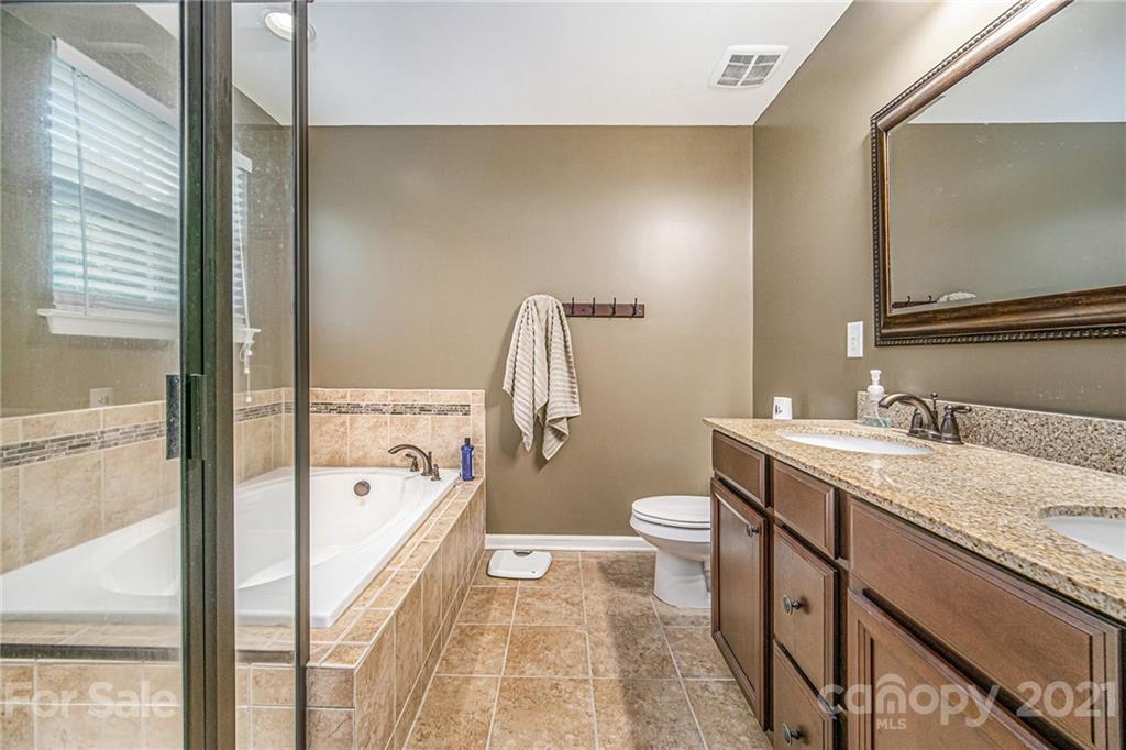 7678 West Berkeley Road Denver, NC 28037 - Photo 22 of 29 a bathroom with a granite countertop sink a toilet a mirror and bathtub