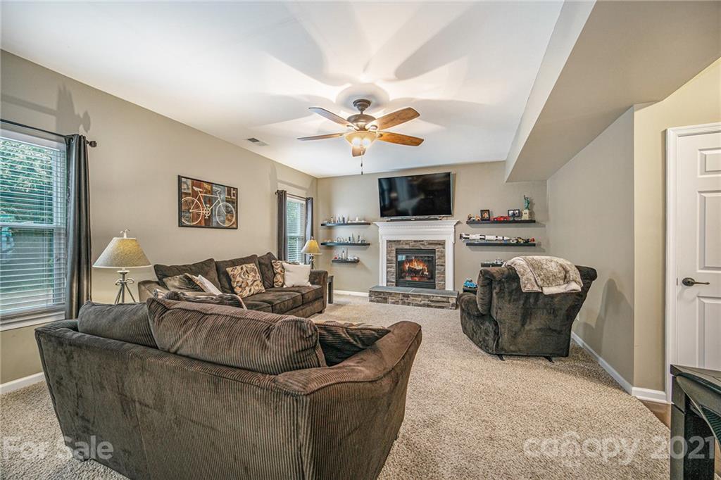 7678 West Berkeley Road Denver, NC 28037 - Photo 7 of 29 a living room with furniture a fireplace and a flat screen tv
